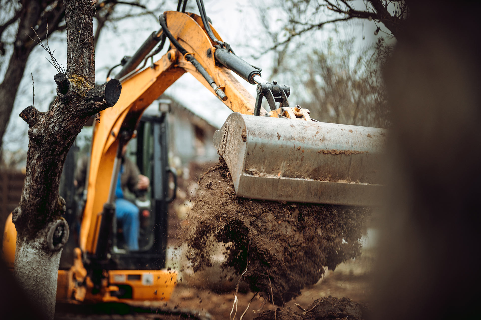 Landschaftsbauarbeiten mit Bagger und Industriemaschinen auf der Baustelle zu Hause.